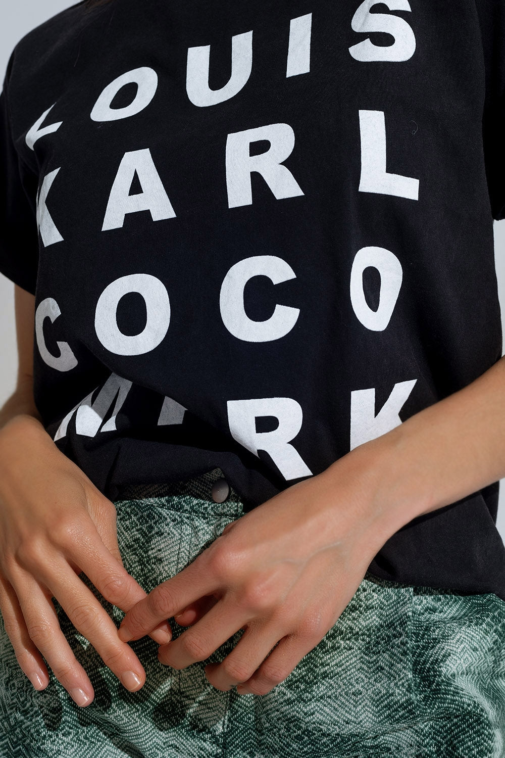T-shirt preta com logótipos de nomes famosos à frente