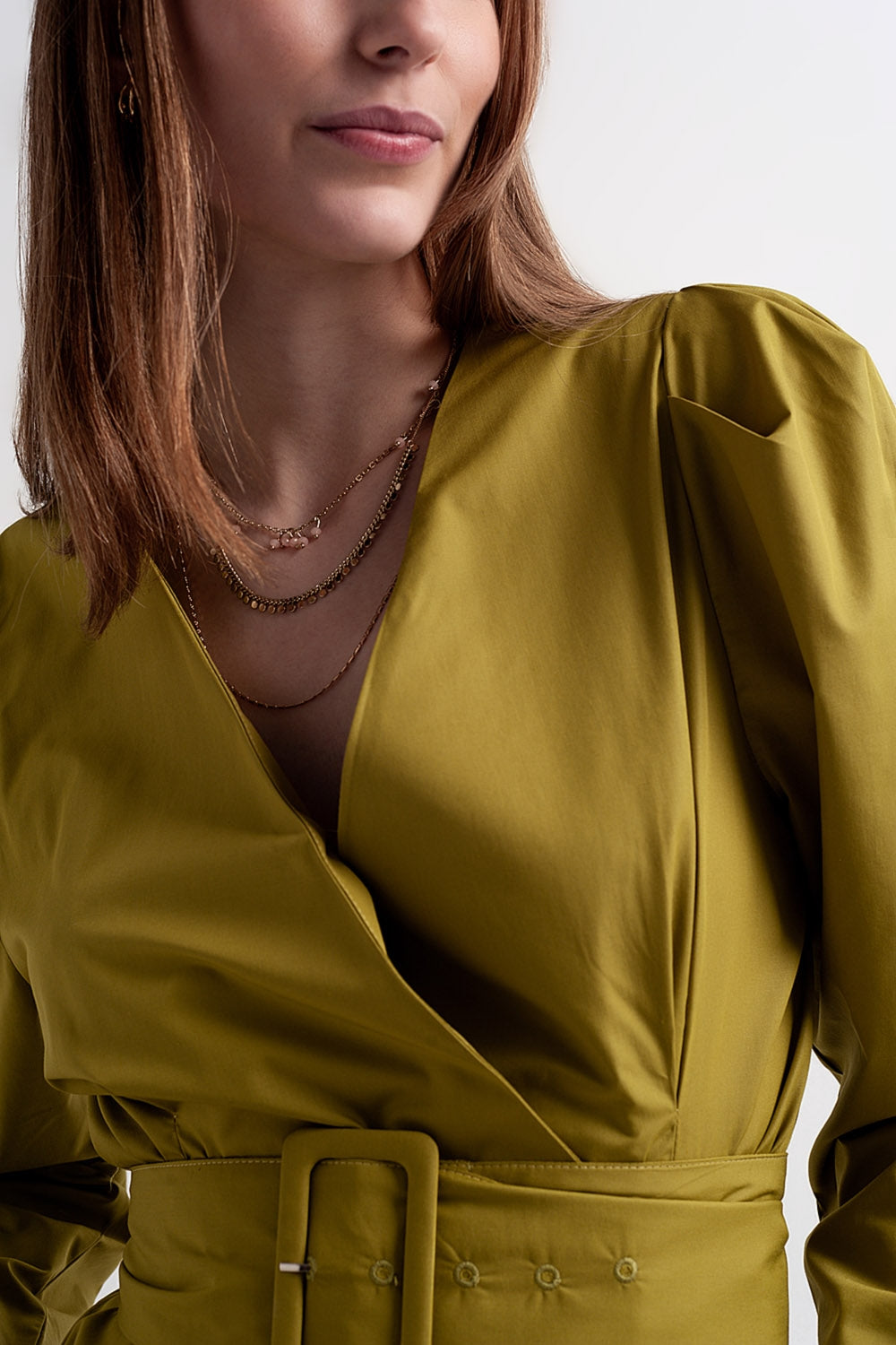 Tampo verde cruzado na frente com manga bufante e detalhe de cinto