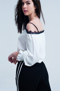 Top branco com renda preta e ombros nus