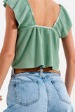 Top curto em ruffled verde com mangas volumosas atadas à frente