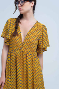 Vestido amarelo com voo e padrão geométrico