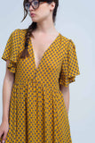 Vestido amarelo com voo e padrão geométrico