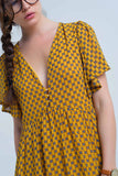 Vestido amarelo com voo e padrão geométrico
