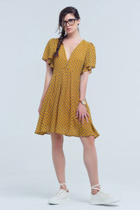 Vestido amarelo com voo e padrão geométrico